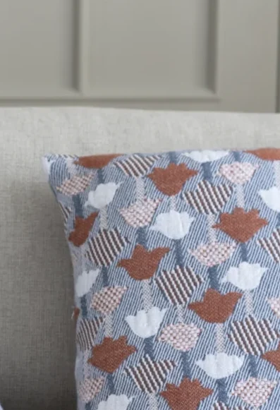 LapuanKankurit-Tulppaani-cushion-cover-rose-blue-and-cinnamon-blue-Revontuli-blanket-rust-rose-1-scaled-e1739956649536.webp