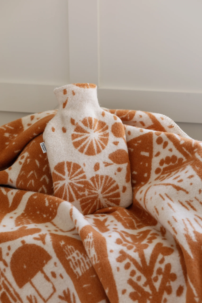 LapuanKankurit-Metsikko-blanket-and-hot-water-bottle-cognac-white-2-scaled.webp
